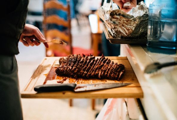 Delicious sliced brisket on a wooden board, perfect for a cozy indoor meal.
